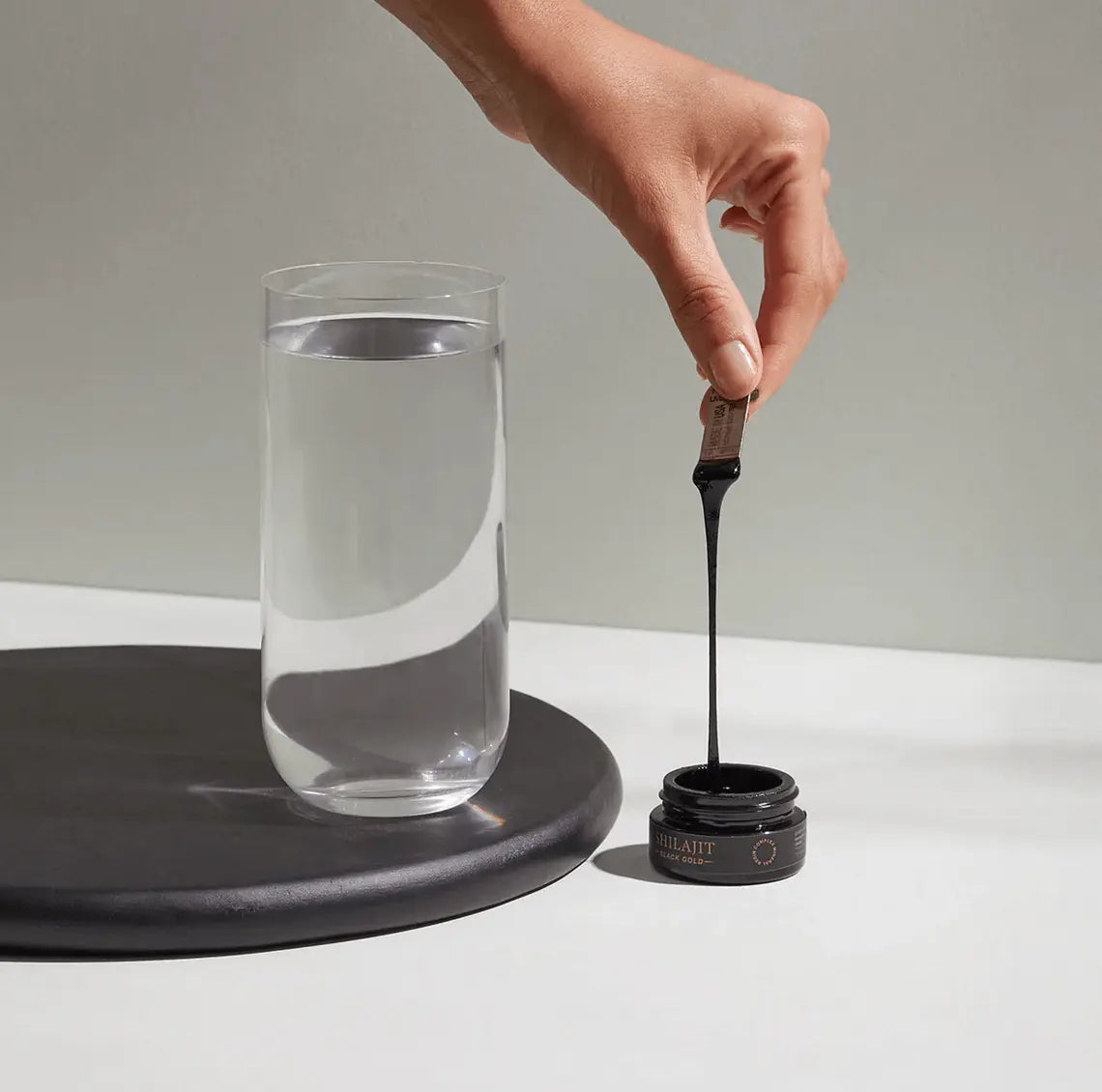 Mineral Shilajit - Cymbiotika being mixed with water for health benefits.